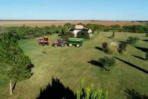 Casa principal del site experimental de Córdoba rodeada por un monte y con presencia de maquinaria agrícola